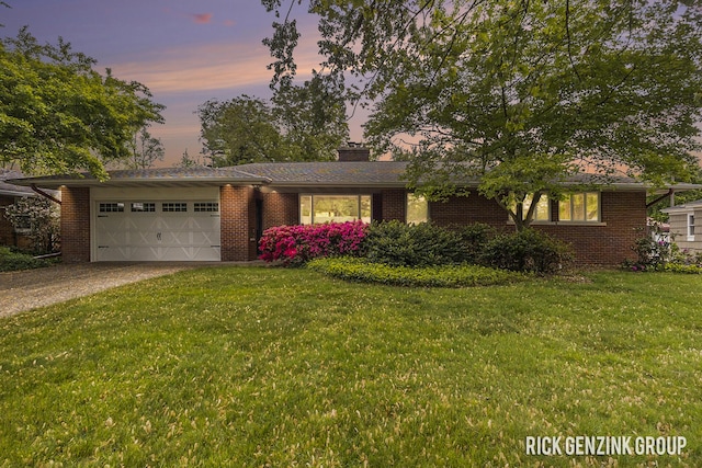 28 W 34th St, Holland, MI 49423 - view of front of home with an attached garage, driveway, brick siding, a front lawn, and a chimney