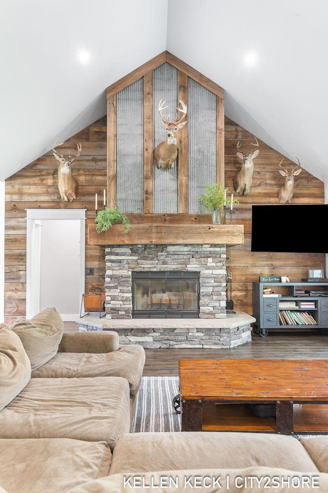 2263 136th Ave, Dorr, MI 49323 - living area featuring lofted ceiling, wooden walls, a stone fireplace, and wood finished floors