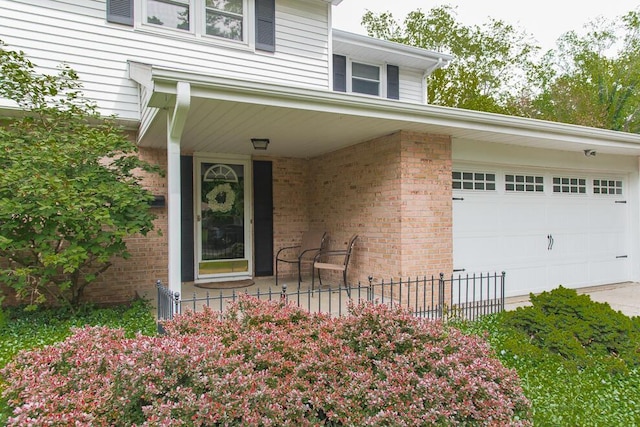2707 Lomond Dr, Kalamazoo, MI 49008 - entrance to property with a garage, brick siding, and covered porch