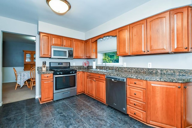 2707 Lomond Dr, Kalamazoo, MI 49008 - kitchen with stainless steel appliances, a sink, tile counters, and brown cabinetry