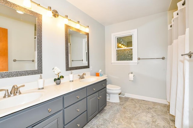 2707 Lomond Dr, Kalamazoo, MI 49008 - full bathroom with double vanity, baseboards, and toilet