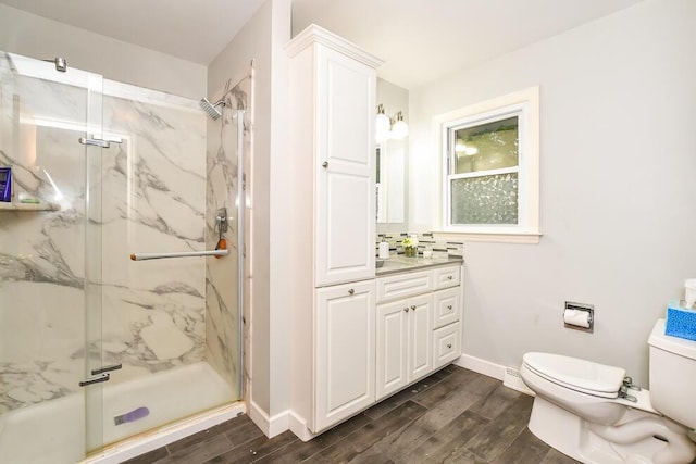 2707 Lomond Dr, Kalamazoo, MI 49008 - full bath with toilet, wood finished floors, a marble finish shower, vanity, and baseboards