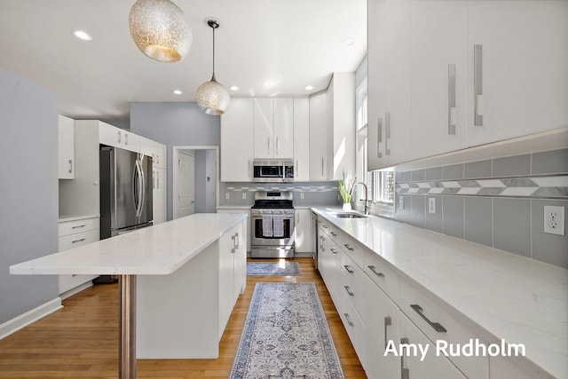 1995 W Glen Ct, Norton Shores, MI 49441 - kitchen featuring appliances with stainless steel finishes, a sink, light wood-style flooring, a center island, and recessed lighting