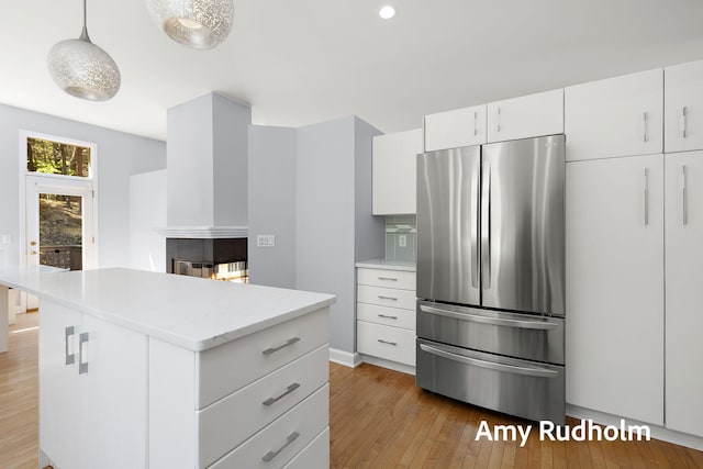 1995 W Glen Ct, Norton Shores, MI 49441 - kitchen with freestanding refrigerator, light wood finished floors, white cabinetry, a kitchen island, and recessed lighting