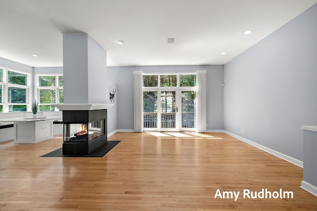 1995 W Glen Ct, Norton Shores, MI 49441 - living area featuring light wood-style flooring, a multi sided fireplace, baseboards, and recessed lighting