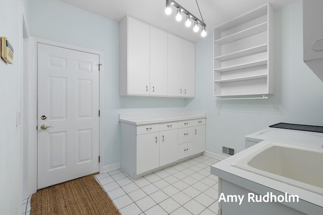 1995 W Glen Ct, Norton Shores, MI 49441 - clothes washing area featuring cabinet space, light tile patterned floors, and baseboards