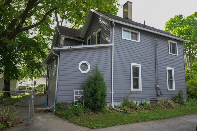 244 E Pearl St, Coldwater, MI 49036 - view of side of property featuring a chimney and fence