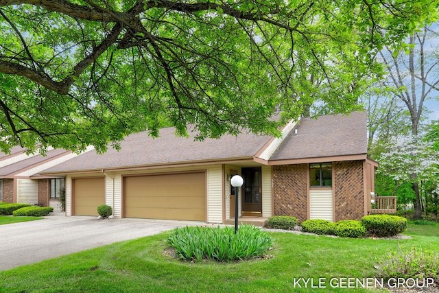 view of front of property featuring a garage, brick siding, a front yard, and driveway