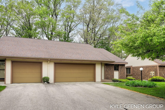 view of front of home with driveway and a shingled roof