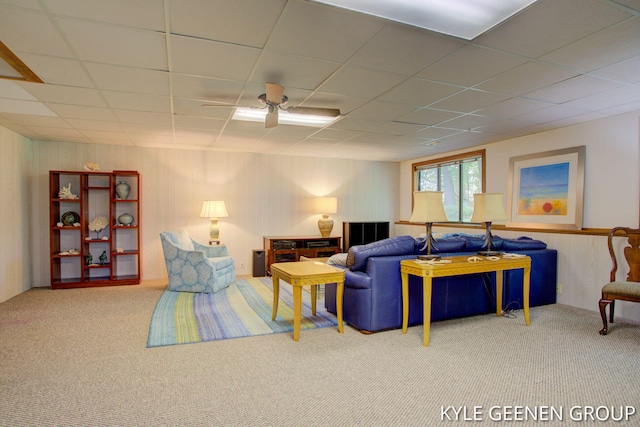 carpeted living room featuring ceiling fan and a drop ceiling