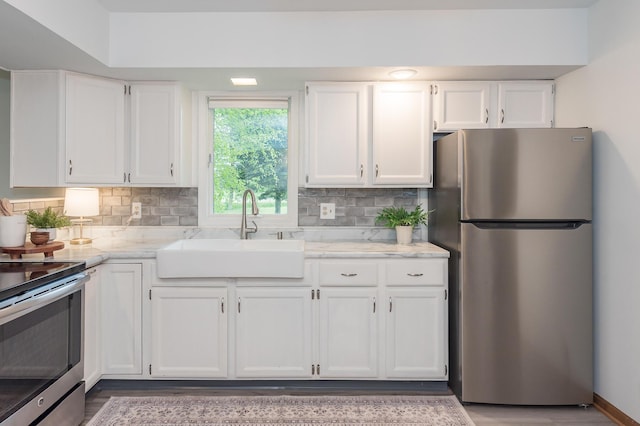 16436 45th Ave, Barryton, MI 49305 - kitchen with appliances with stainless steel finishes, a sink, white cabinets, and backsplash