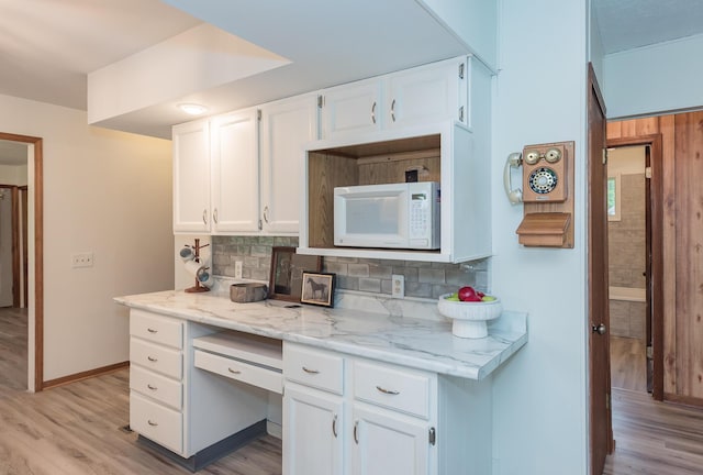 16436 45th Ave, Barryton, MI 49305 - kitchen featuring white microwave, backsplash, light wood-style flooring, and white cabinets