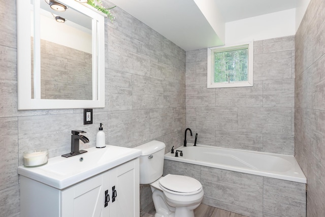 16436 45th Ave, Barryton, MI 49305 - full bath featuring tiled bath, toilet, vanity, tile walls, and wood finished floors