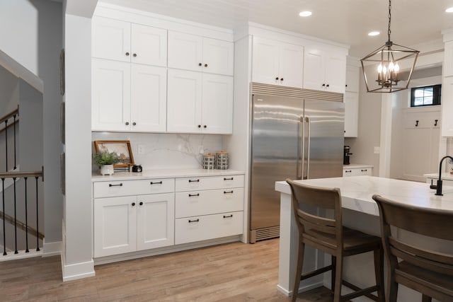 8182 Country Rail Dr SW, Byron Center, MI 49315 - kitchen featuring built in fridge, a chandelier, recessed lighting, white cabinetry, and light wood-style floors