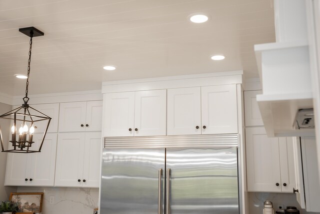 8182 Country Rail Dr SW, Byron Center, MI 49315 - kitchen view of stainless steel built in fridge, a chandelier, white cabinets, hanging light fixtures, and recessed lighting
