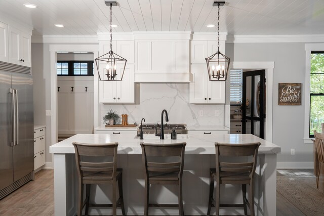 8182 Country Rail Dr SW, Byron Center, MI 49315 - kitchen featuring stainless steel built in fridge, a chandelier, tasteful backsplash, recessed lighting, and a center island with sink