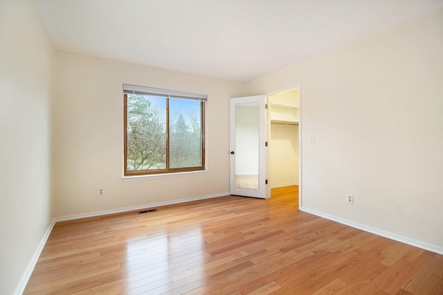 1 Northwick Ct, Ann Arbor, MI 48105 - unfurnished bedroom with light wood-style flooring, baseboards, and a spacious closet