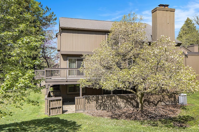 1 Northwick Ct, Ann Arbor, MI 48105 - rear view of house featuring a yard, a chimney, a wooden deck, and roof with shingles