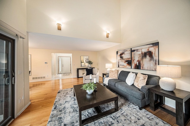1 Northwick Ct, Ann Arbor, MI 48105 - living room with light wood-style floors, a towering ceiling, and baseboards