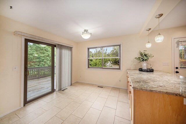 1 Northwick Ct, Ann Arbor, MI 48105 - unfurnished dining area featuring healthy amount of natural light, baseboards, and light tile patterned flooring