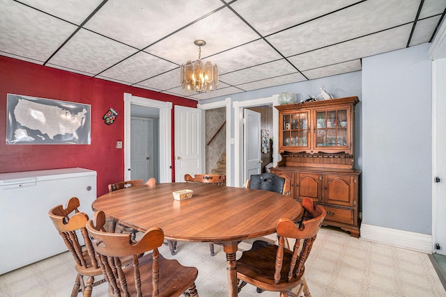 2640 Terminal St, Niles, MI 49120 - dining room featuring light flooring, a chandelier, stairs, a drop ceiling, and baseboards