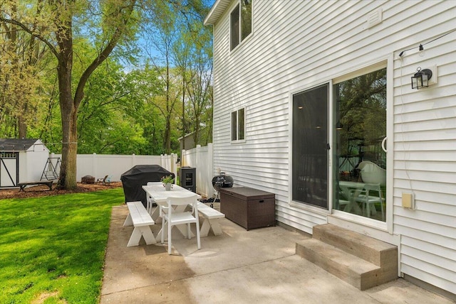 view of patio featuring entry steps, a storage shed, an outbuilding, and outdoor dining area