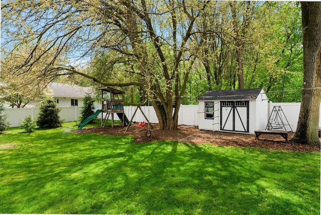 view of yard with a storage shed, a playground, and an outbuilding