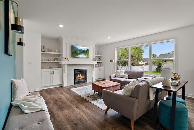 living room featuring dark wood-style floors, a fireplace, recessed lighting, and baseboards