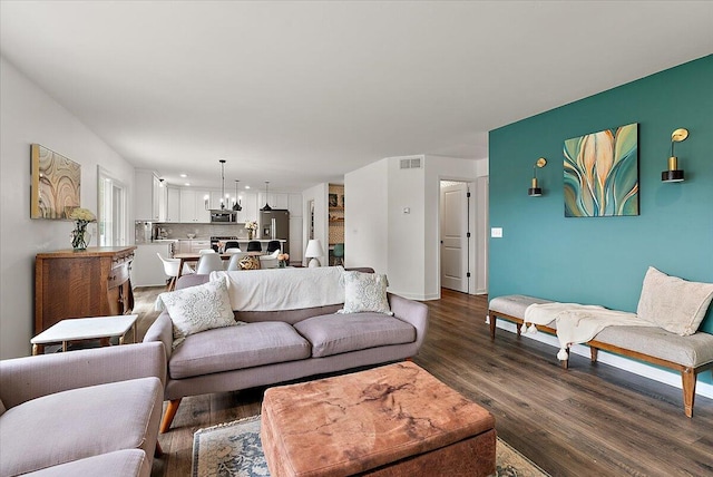 living room featuring a chandelier, dark wood-style flooring, baseboards, and recessed lighting