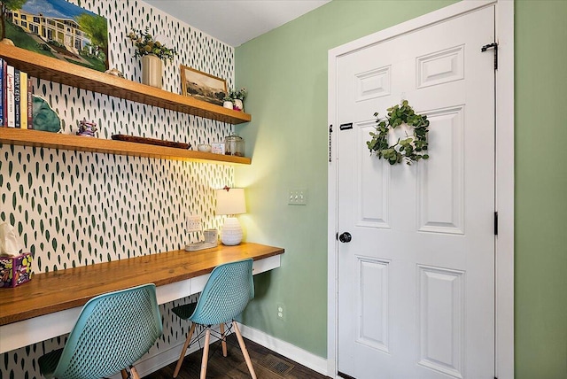 office space featuring baseboards and built in study area