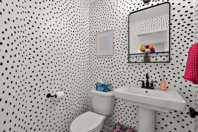 half bathroom featuring toilet and a sink