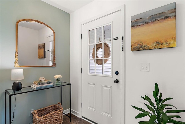 entryway with dark wood-type flooring and baseboards