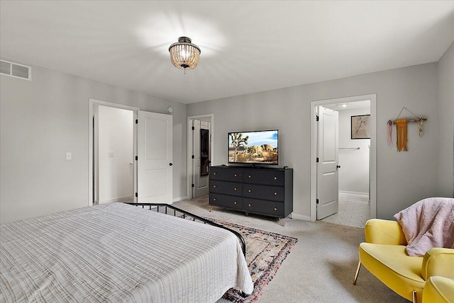 bedroom featuring light colored carpet, baseboards, and connected bathroom