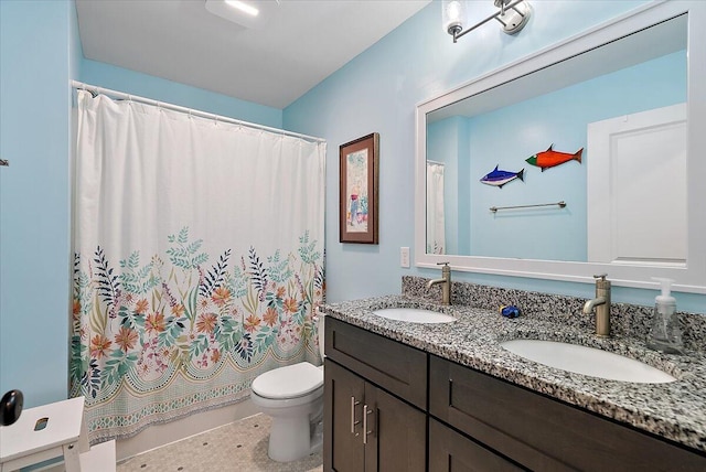 bathroom featuring toilet and double vanity