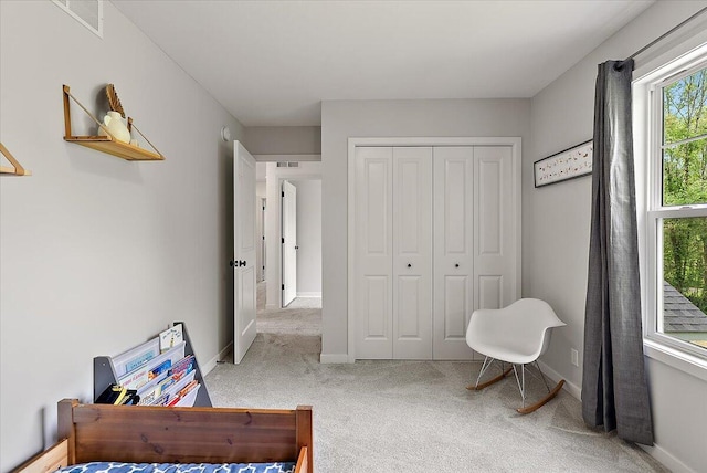 carpeted bedroom with baseboards and a closet