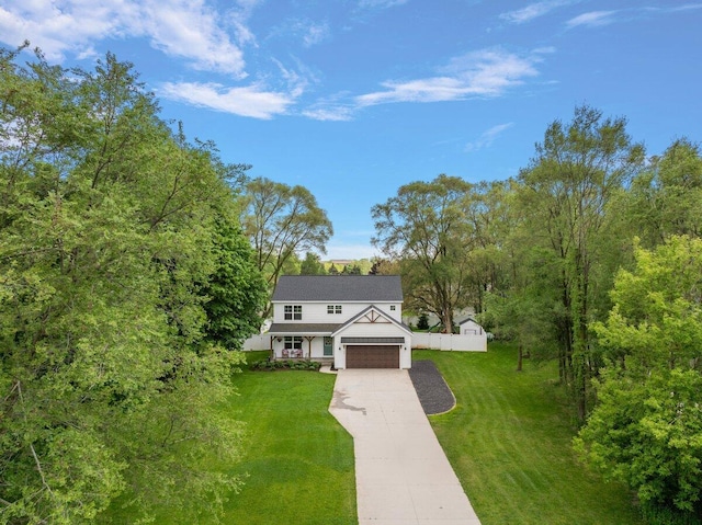 view of front facade featuring a front yard, concrete driveway, and an attached garage