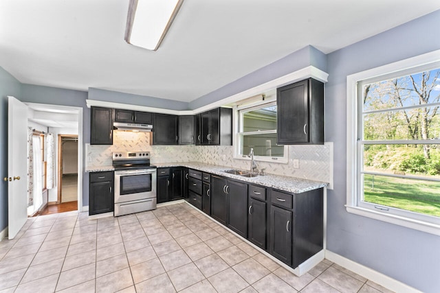 kitchen featuring stainless steel range with electric cooktop, a sink, under cabinet range hood, dark cabinets, and backsplash