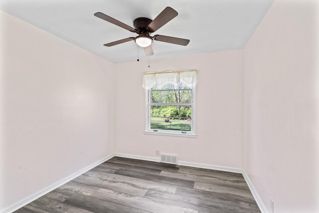 spare room featuring wood finished floors, baseboards, and a ceiling fan