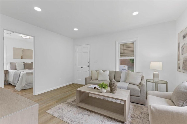 living area with light wood-type flooring, baseboards, and recessed lighting
