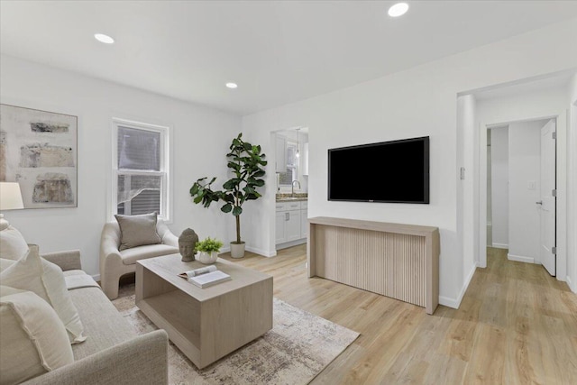 living room with light wood-type flooring, baseboards, and recessed lighting