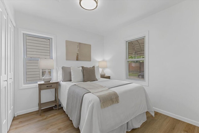 bedroom with baseboards and light wood-type flooring