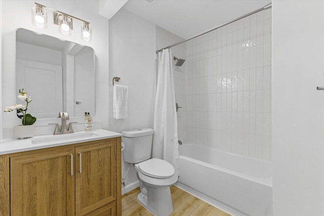 bathroom featuring toilet, wood finished floors, vanity, and shower / bathtub combination with curtain