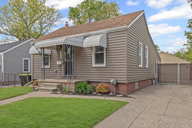 view of front of house featuring roof with shingles and a gate