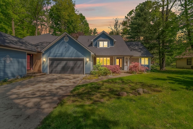 586 Schaeffer Dr, Coldwater, MI 49036 - view of front facade with driveway, an attached garage, a lawn, and brick siding
