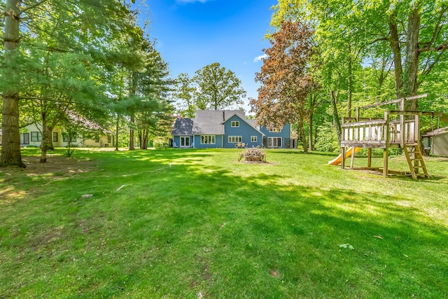 586 Schaeffer Dr, Coldwater, MI 49036 - view of green lawn with a playground and an outdoor fire pit