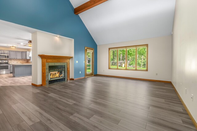 586 Schaeffer Dr, Coldwater, MI 49036 - unfurnished living room featuring high vaulted ceiling, ceiling fan, beam ceiling, wood finished floors, and a fireplace