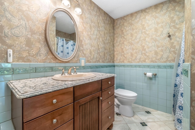 586 Schaeffer Dr, Coldwater, MI 49036 - bathroom with tile walls, wallpapered walls, toilet, wainscoting, and vanity