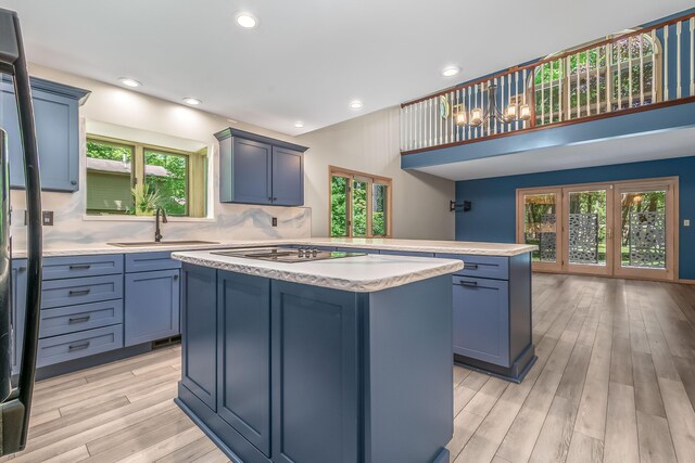 586 Schaeffer Dr, Coldwater, MI 49036 - kitchen featuring a sink, a center island, light countertops, light wood finished floors, and cooktop