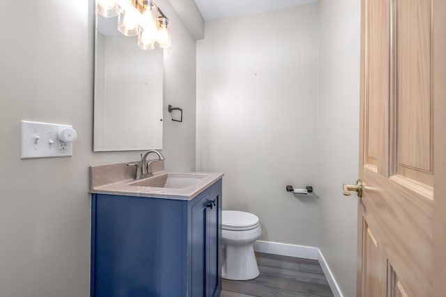 586 Schaeffer Dr, Coldwater, MI 49036 - bathroom with baseboards, wood finished floors, toilet, and vanity