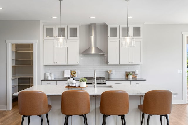 9156 Perry Ct Lot C, Lot C, Zeeland, MI 49464 - kitchen featuring wall chimney range hood, light wood-style floors, backsplash, a kitchen island with sink, and recessed lighting